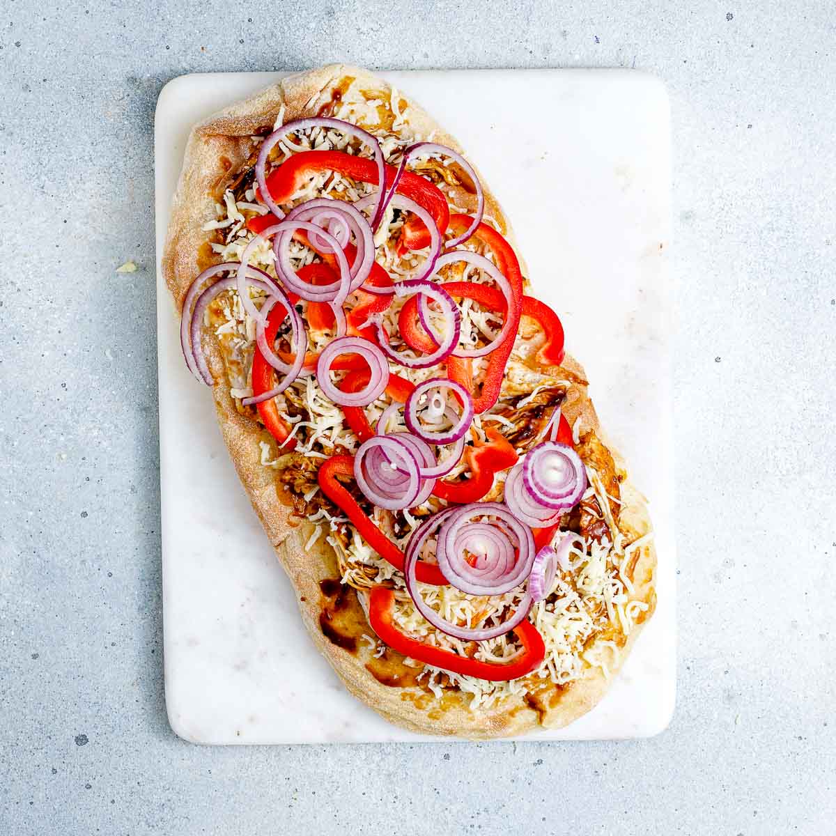 Flatbread assembled with toppings.