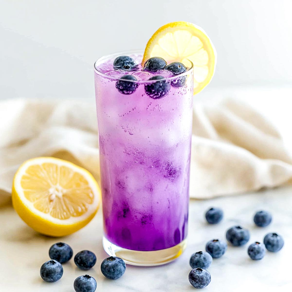 Blueberry lemonade spritzer topped with fresh blueberries and lemon wheel.