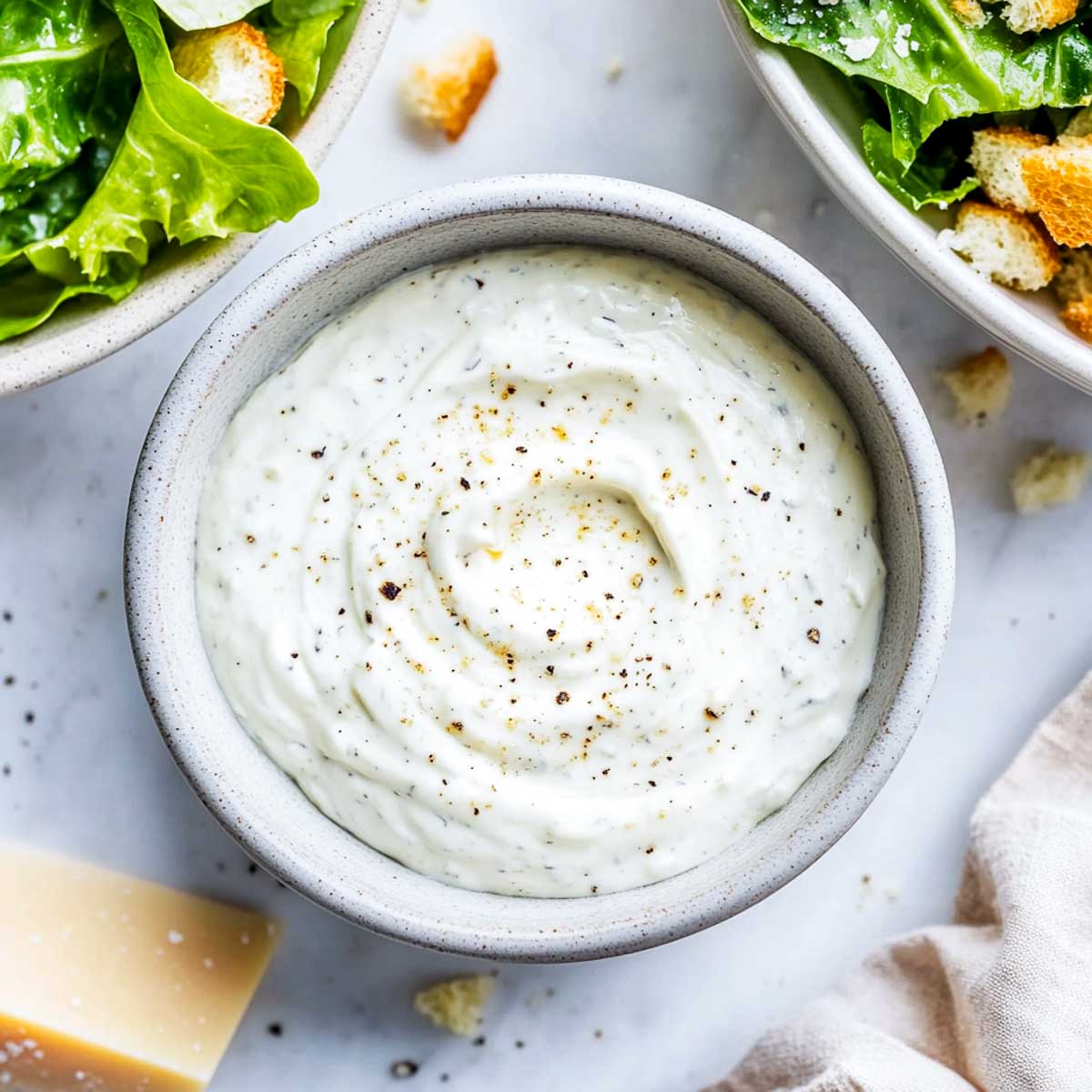 Caesar Greek yogurt dressing with romaine lettuce, croutons, and Parmesan wedge.