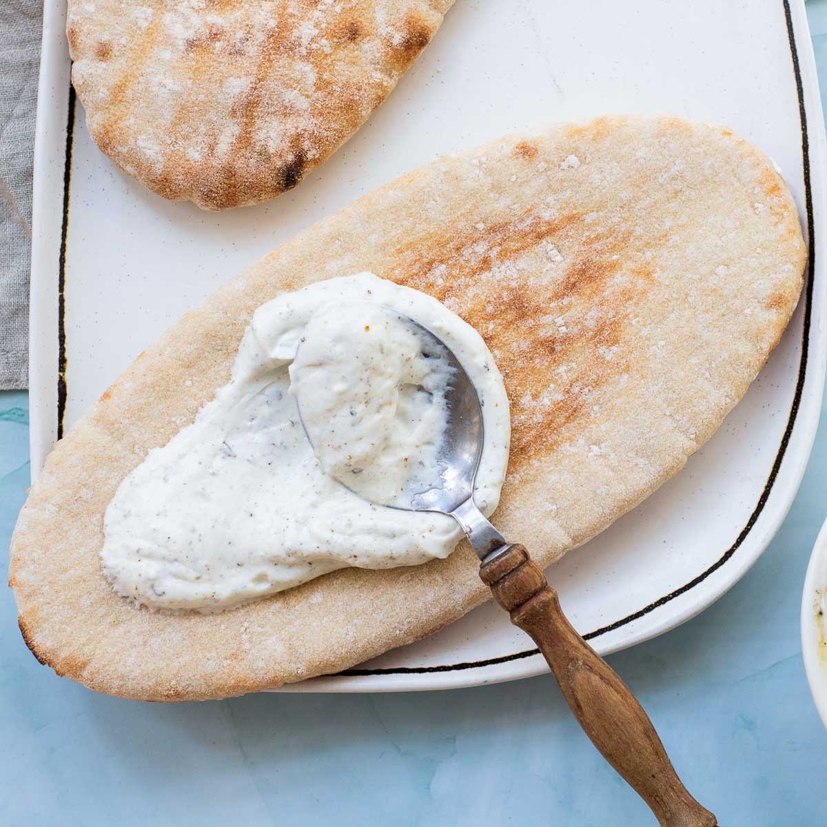 Yogurt sauce spread on warm pita bread.
