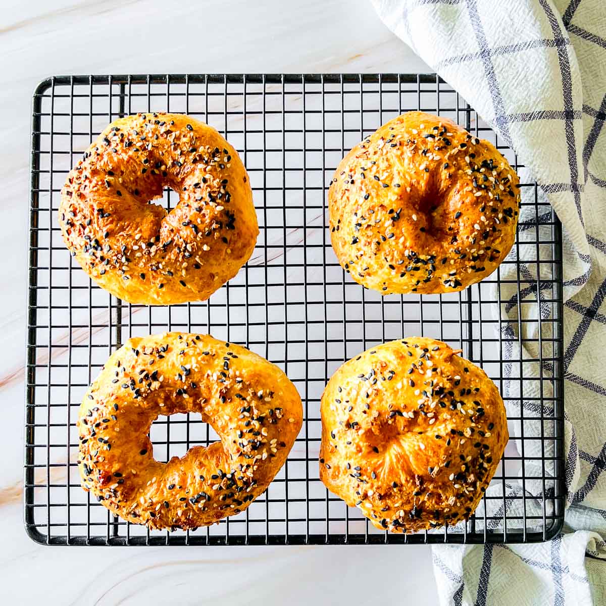 Cottage cheese bagels cooling on a wire rack.