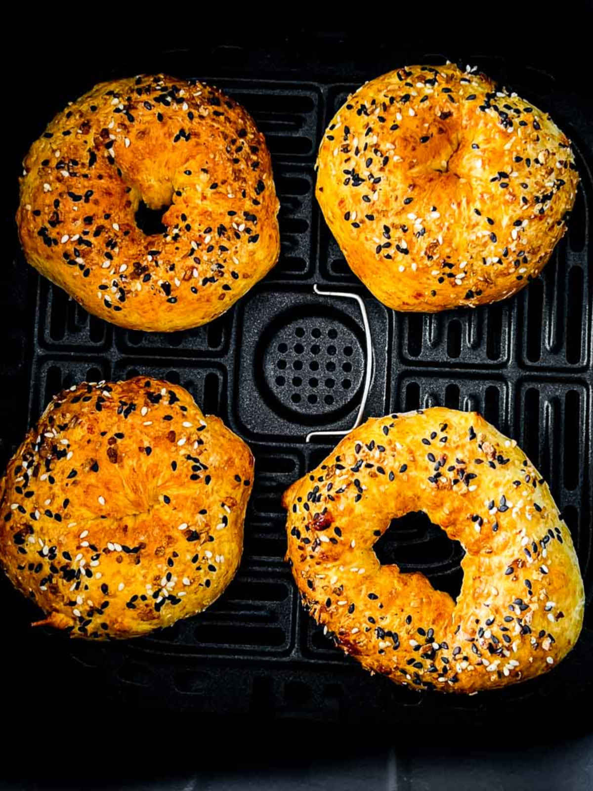 Cottage cheese bagels in air fryer basket.