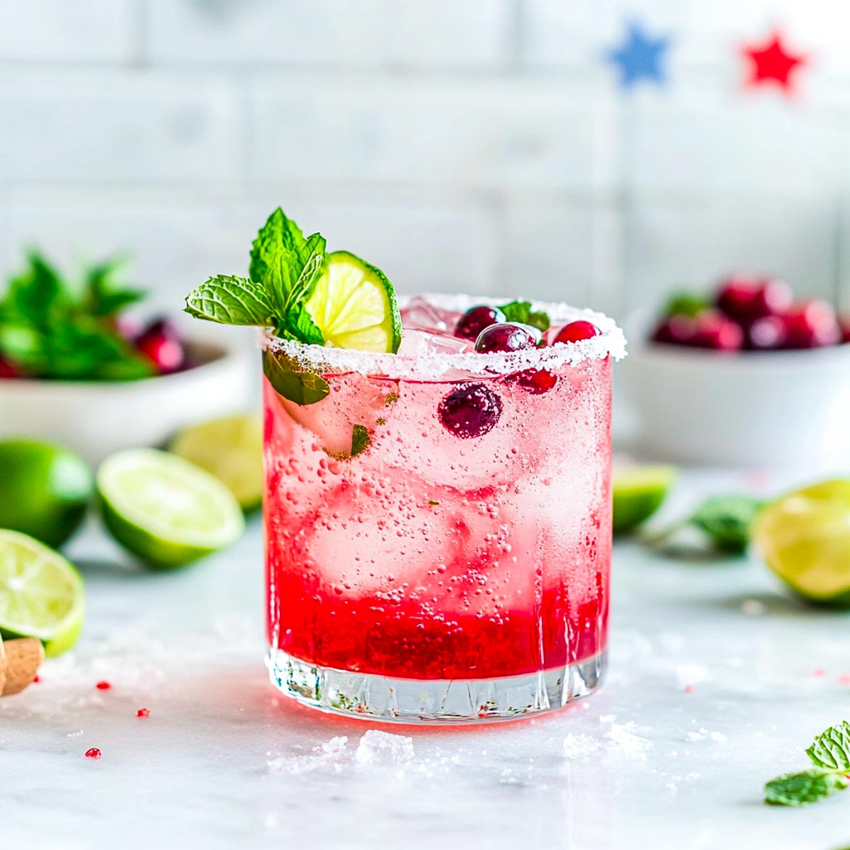 A glass of fireworks fizz mocktail on a white marble surface.