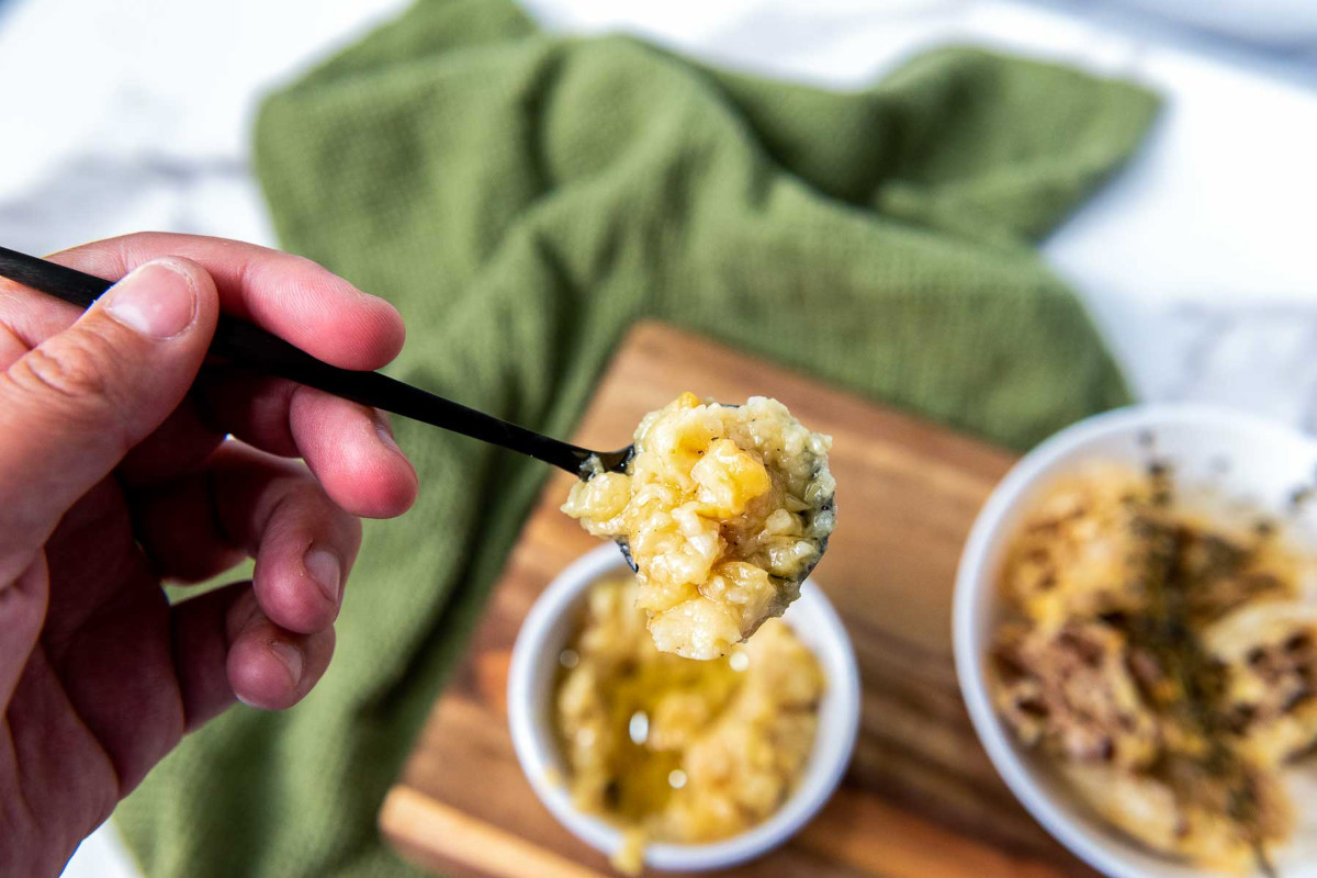 A spoon of garlic confit over the ramiken bowl.