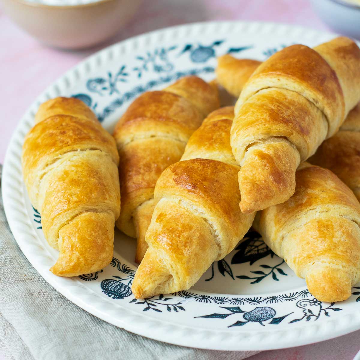 Side view close up of croissants on a white plate.