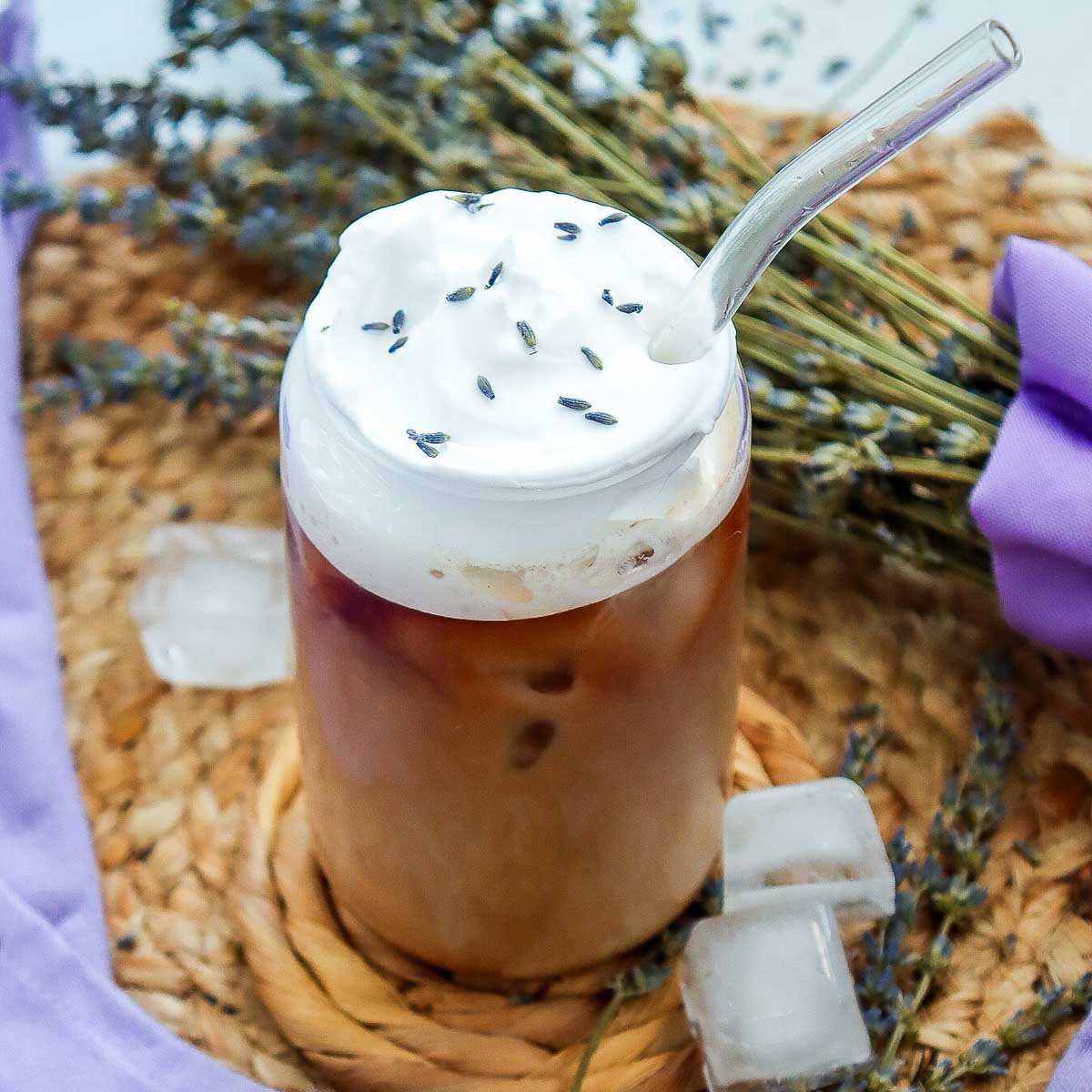 Lavender vanilla iced coffee with fresh lavender flowers in the background.