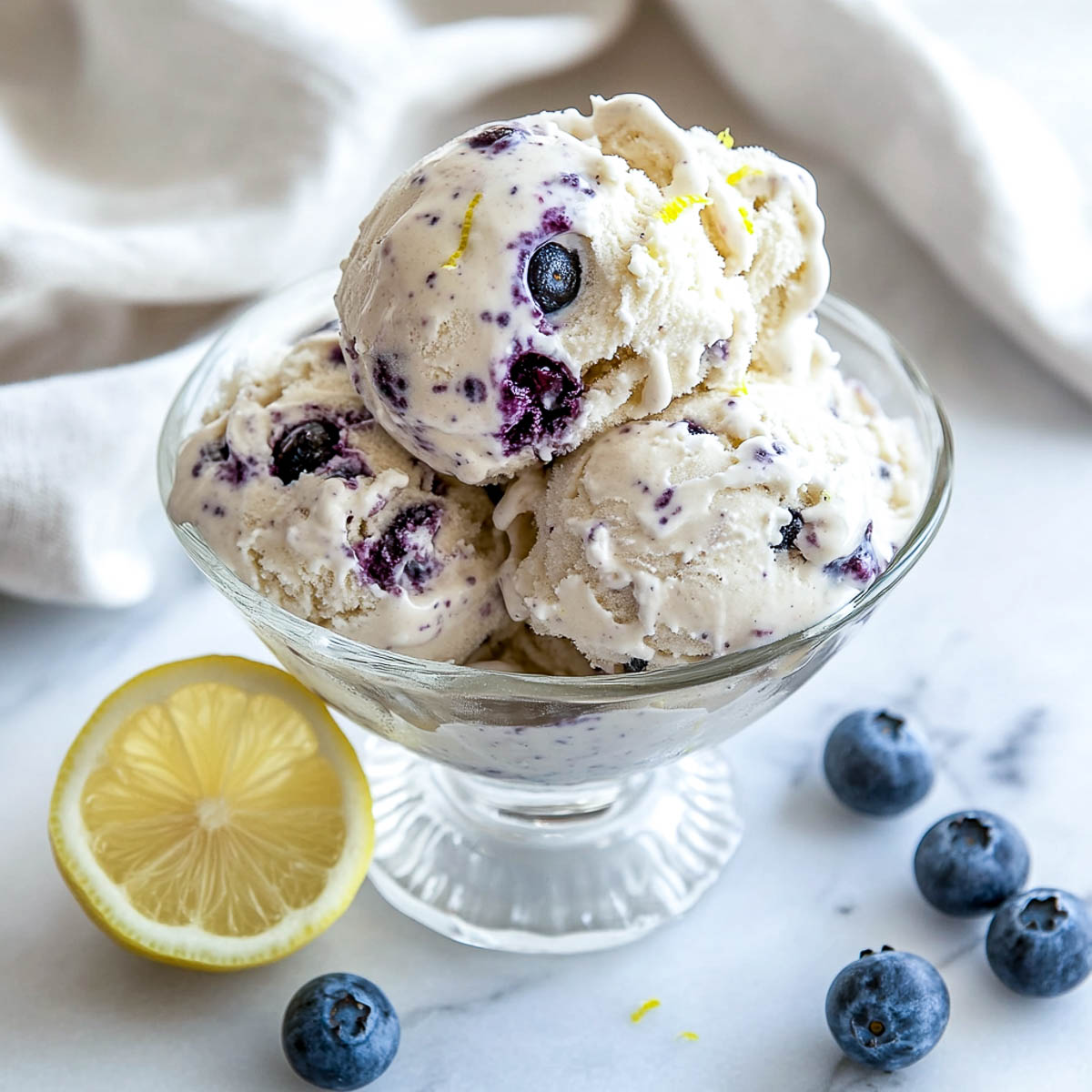 A bowl of lemon blueberry ice cream with fresh blueberry and lemon on the background.