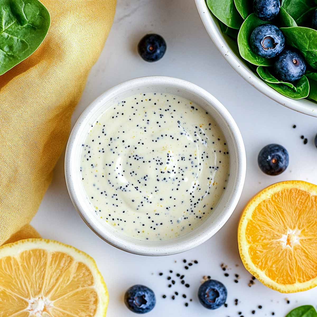 Lemon poppy seed Greek yogurt dressing with spinach, blueberries, and lemon slices.