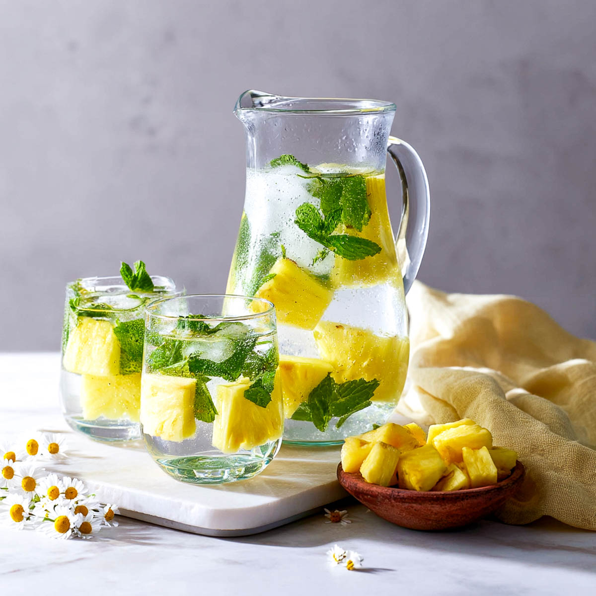 Pineapple mint water in a jug and in glasses.