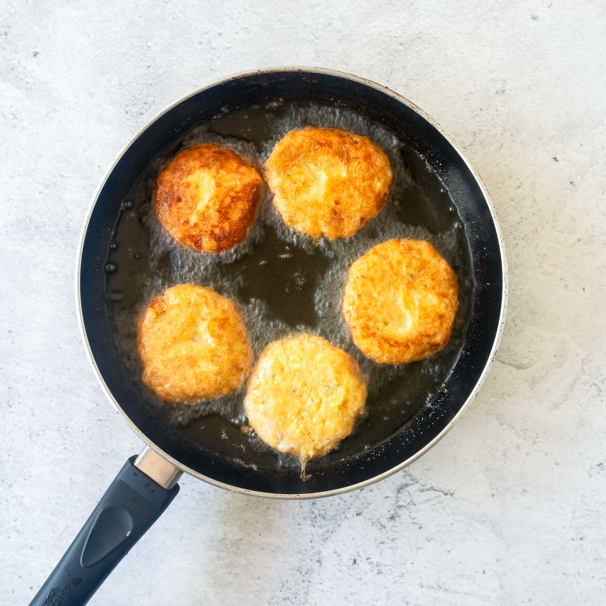 Patties shallow fried in a skillet.