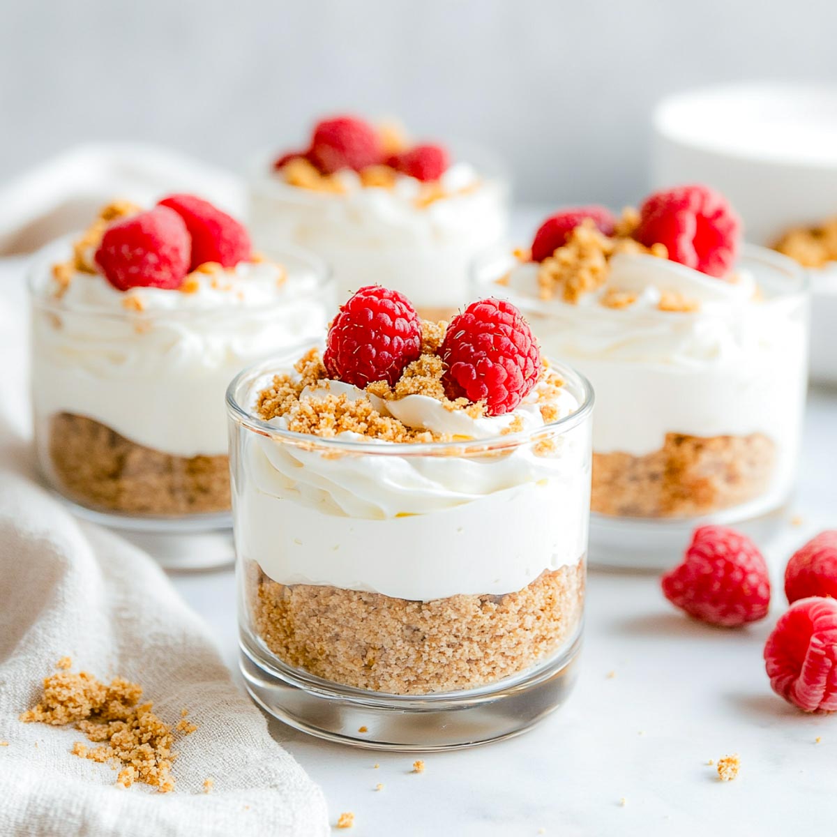 Protein cheesecake cups topped with raspberries.