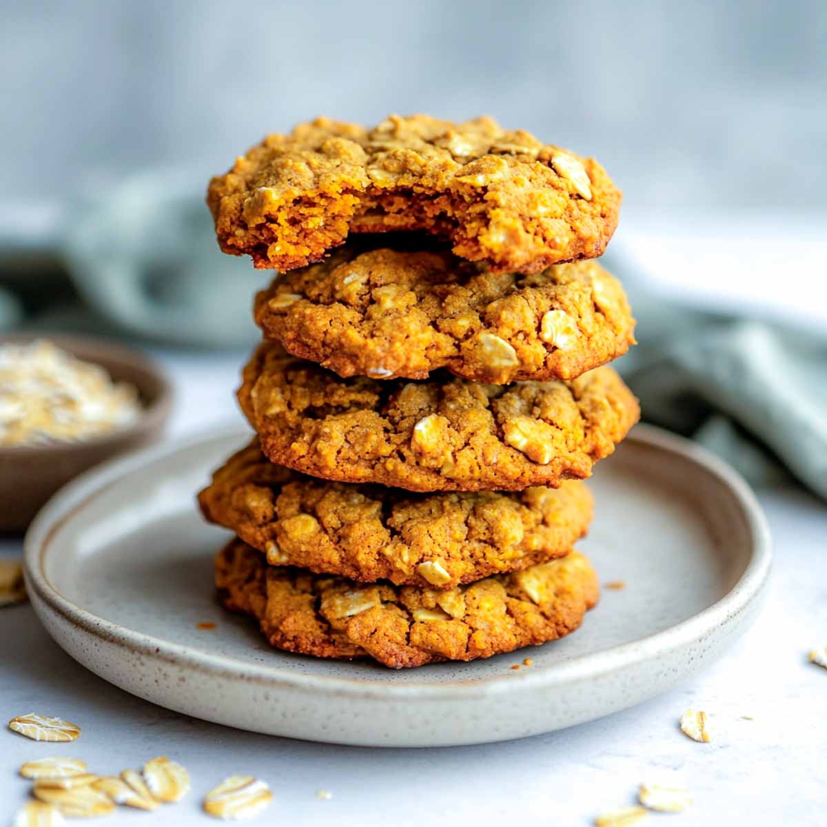 Stack of soft pumpkin oat cookies with rustic texture and cozy fall spices.