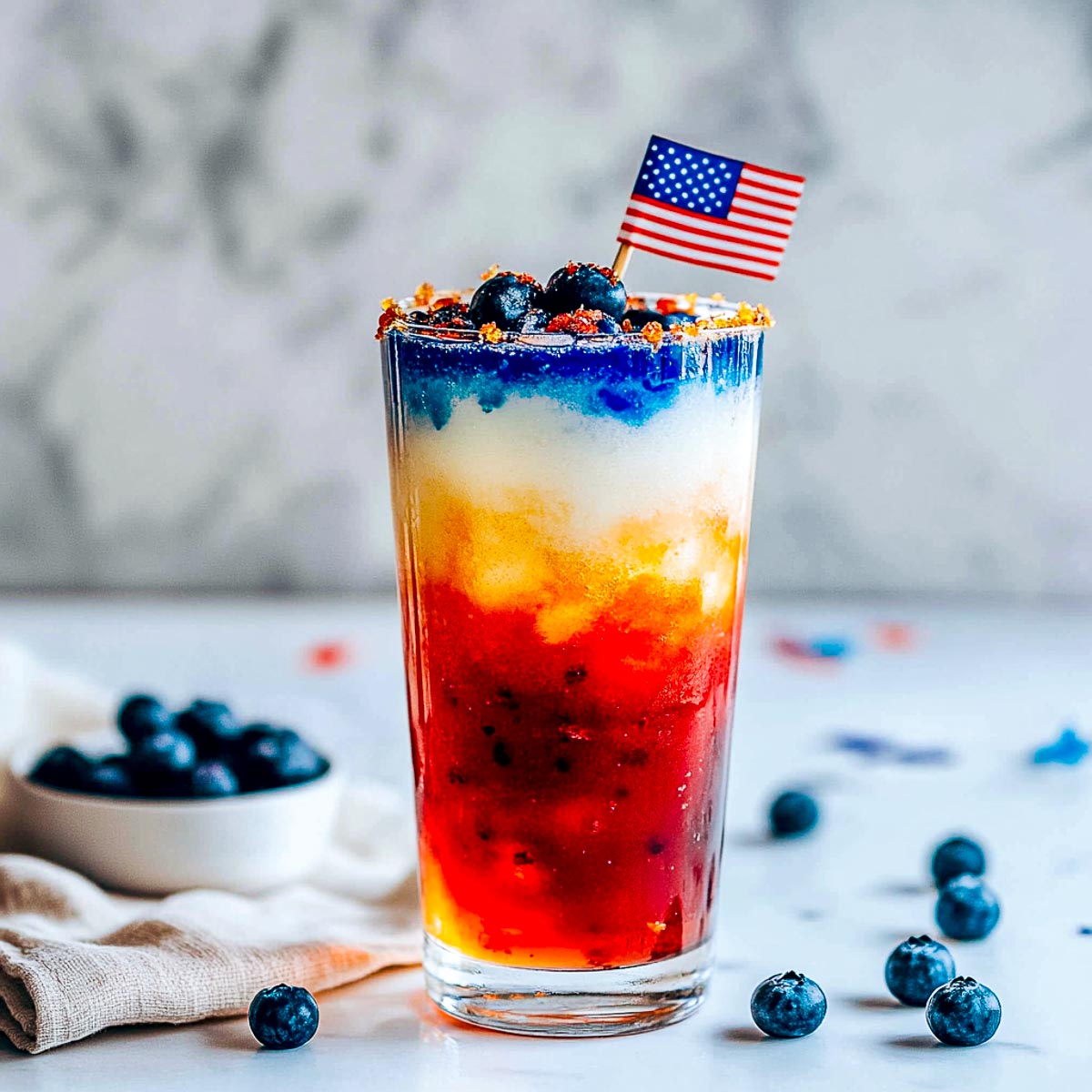 Layered mocktail using red, white, and blue drinks.