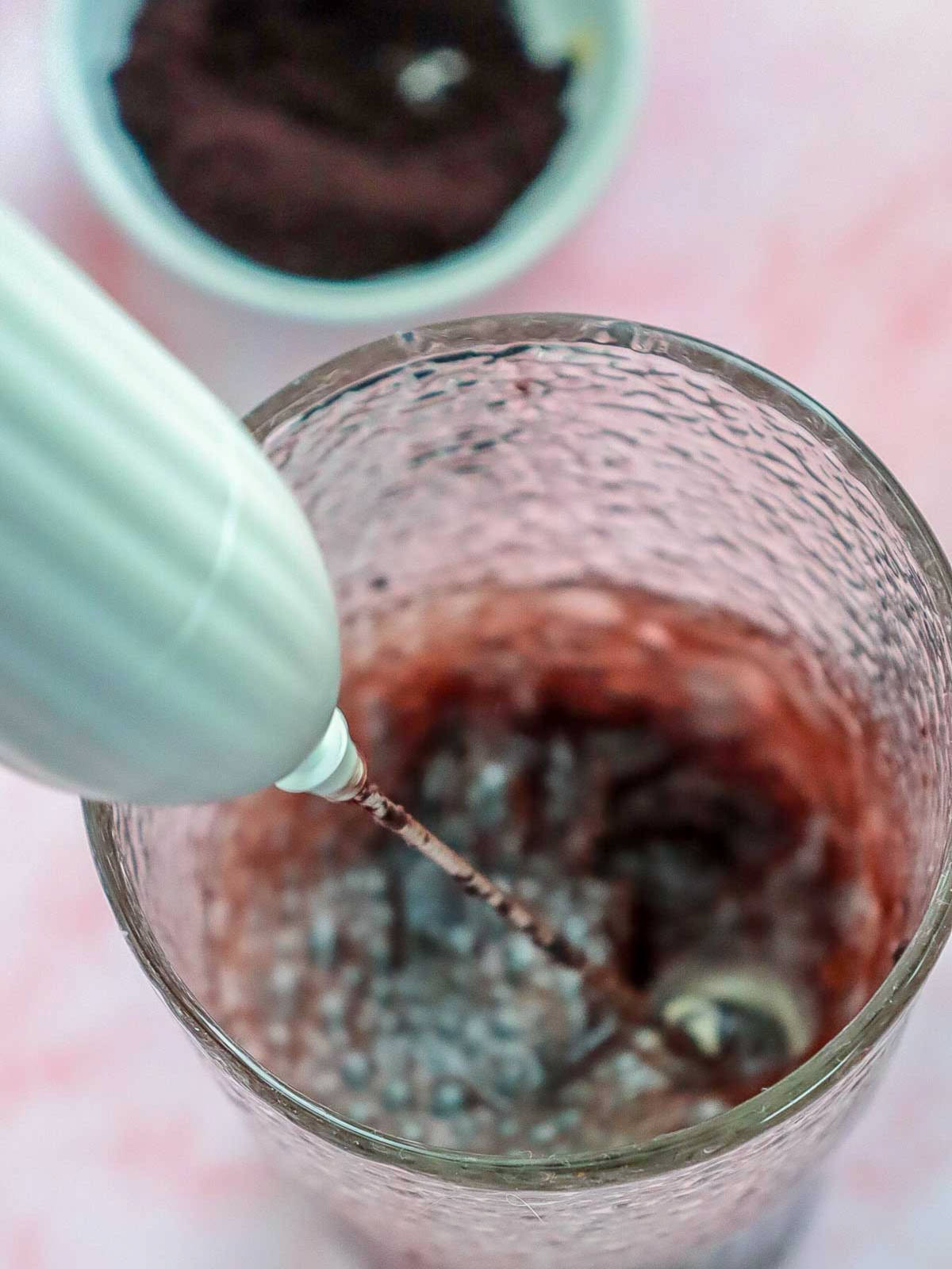 Acai berry powder whisked with water in a glass.