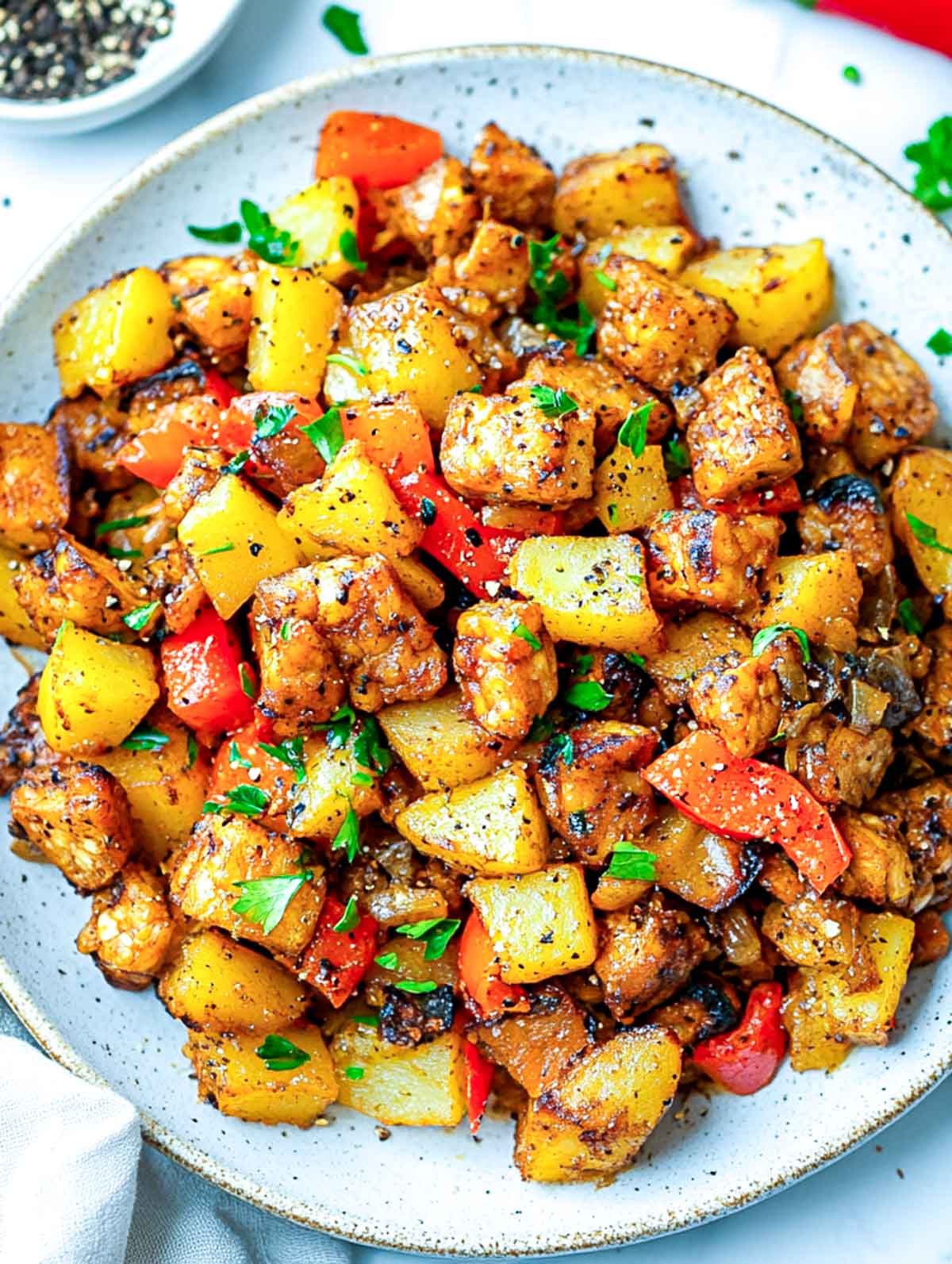 Close up view of tempeh breakfast hash on a serving plate.