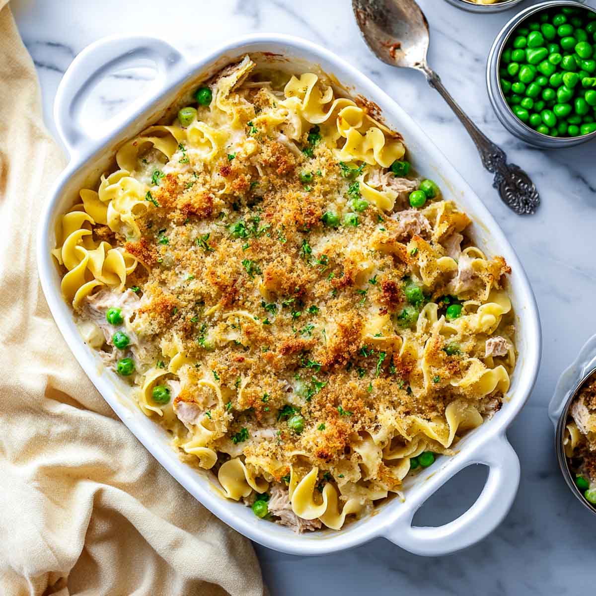 Baked tuna noodle casserole with peas and crispy breadcrumb topping.