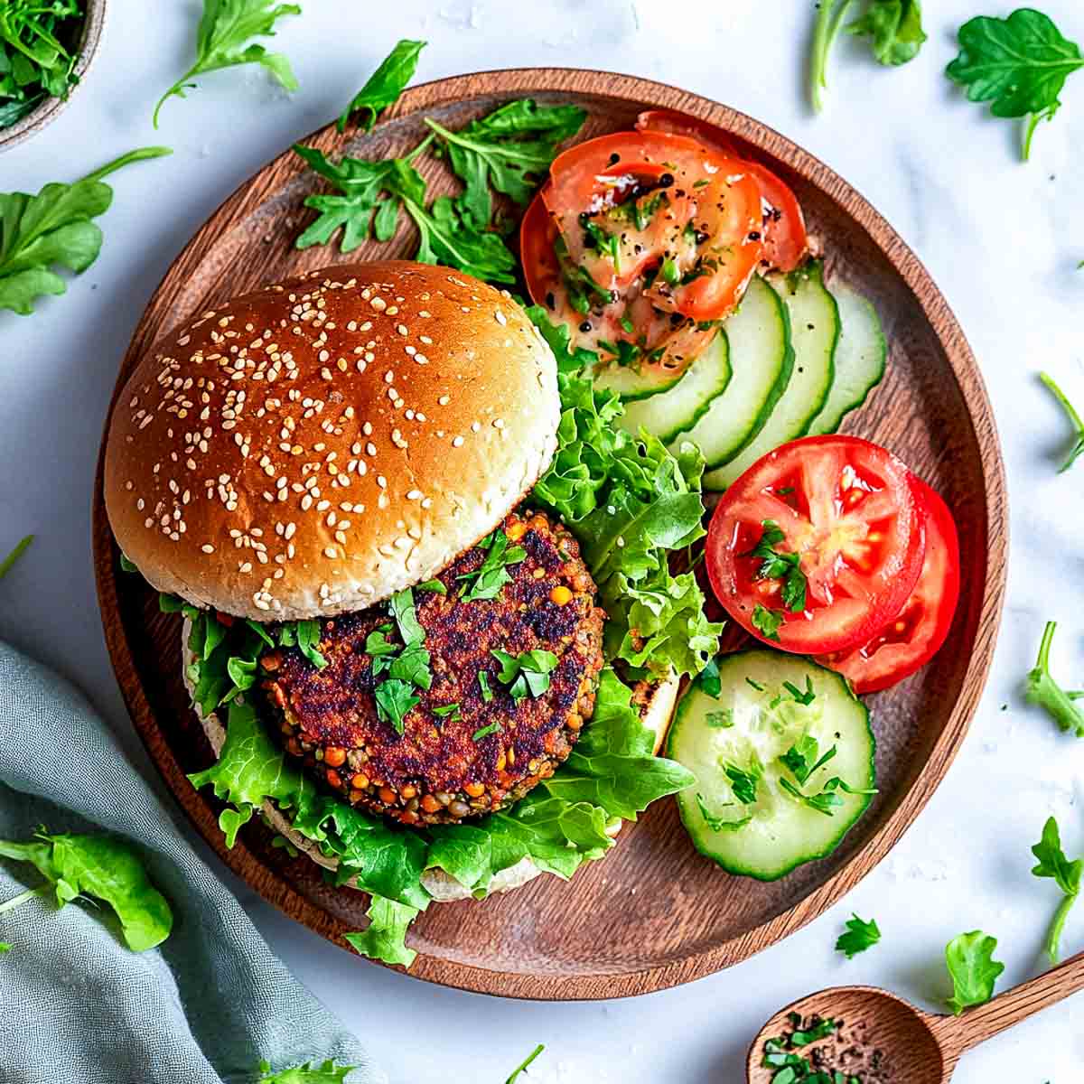 Vegan bean and lentil burger in a bun with lettuce and sliced tomato.