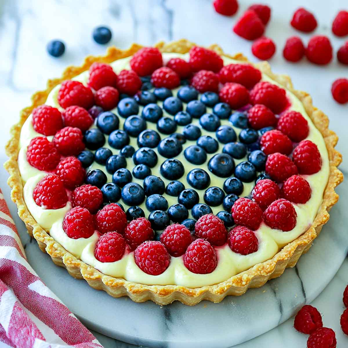 4th of July fruit tart with blueberries and raspberries on white cream filling.