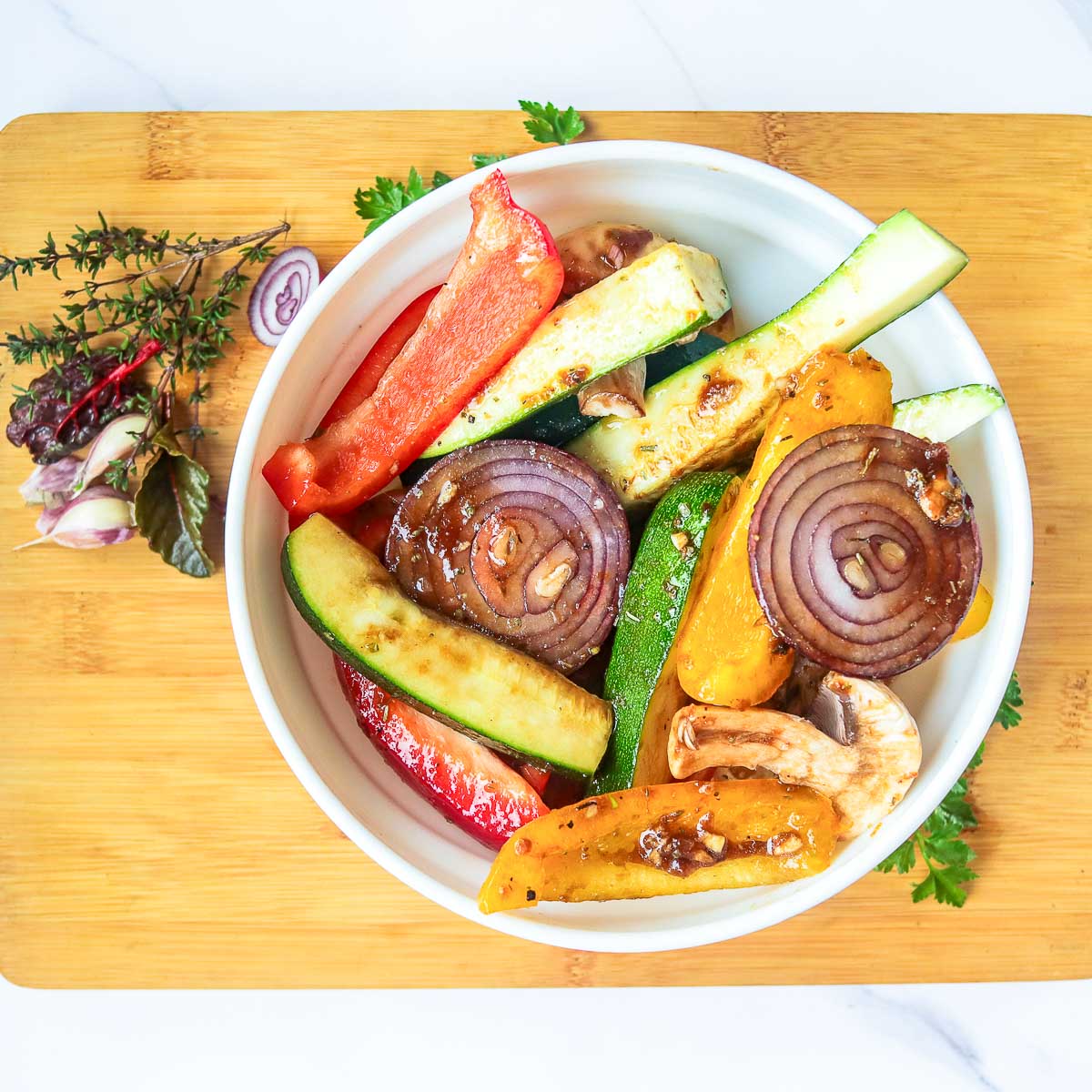 Vegetables marinated and placed in a wide white bowl.