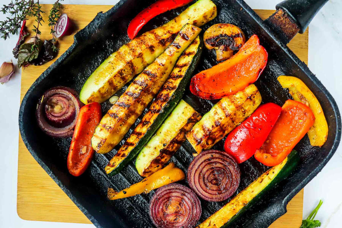 Vegetables being grilled on a grill pan.