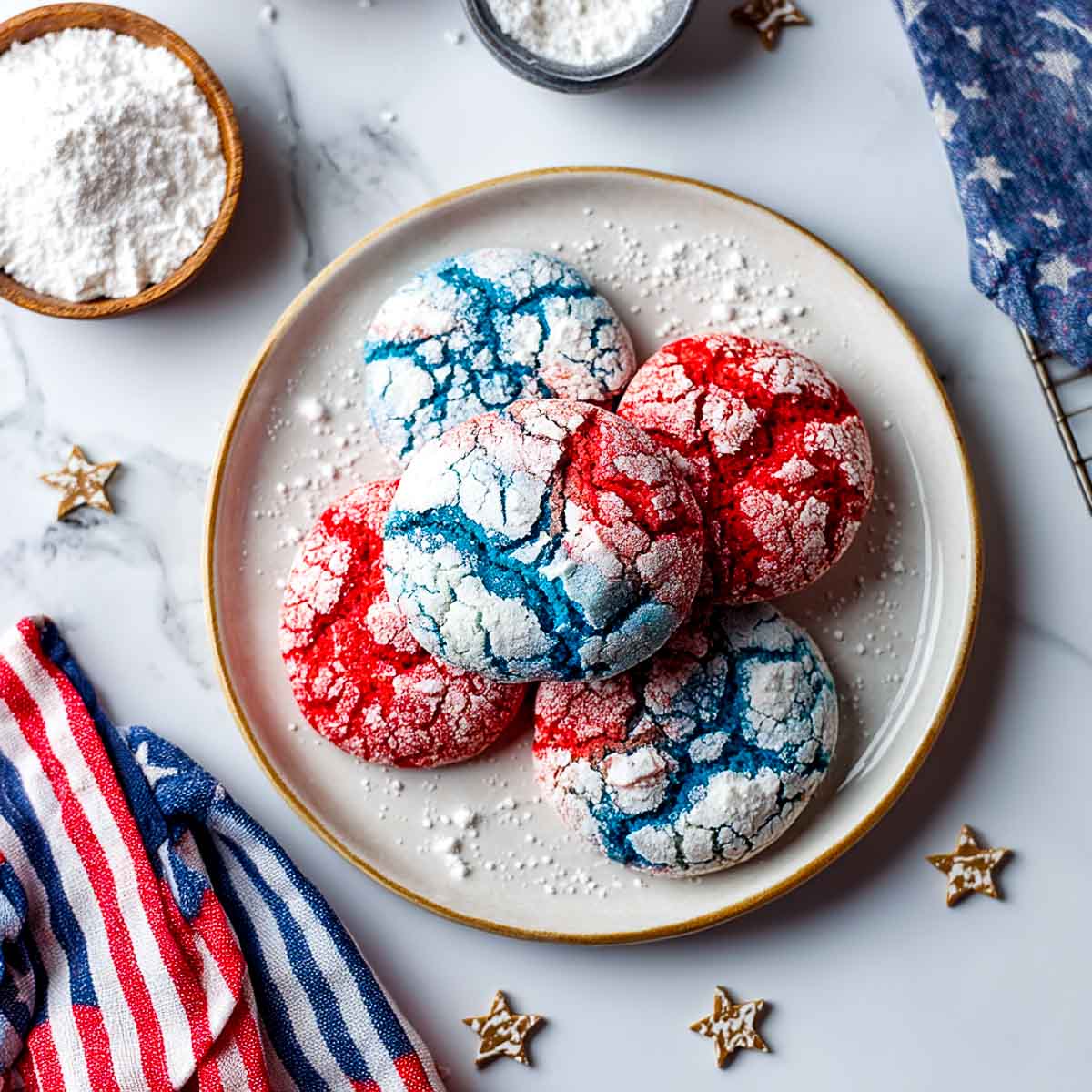 Top-down view of red and blue crinkle cookies dusted with powdered sugar.