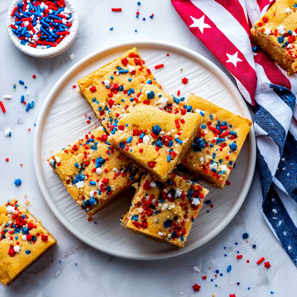 Top-down view of golden blondie bars topped with red, white, and blue sprinkles.