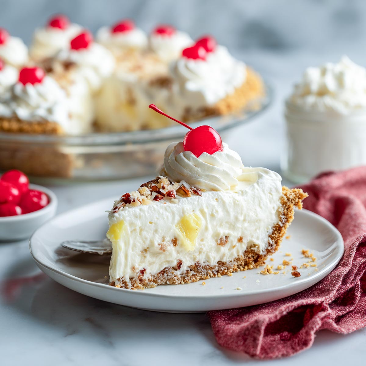 Slice of creamy million dollar pie with pineapple, whipped topping, and a cherry on top.