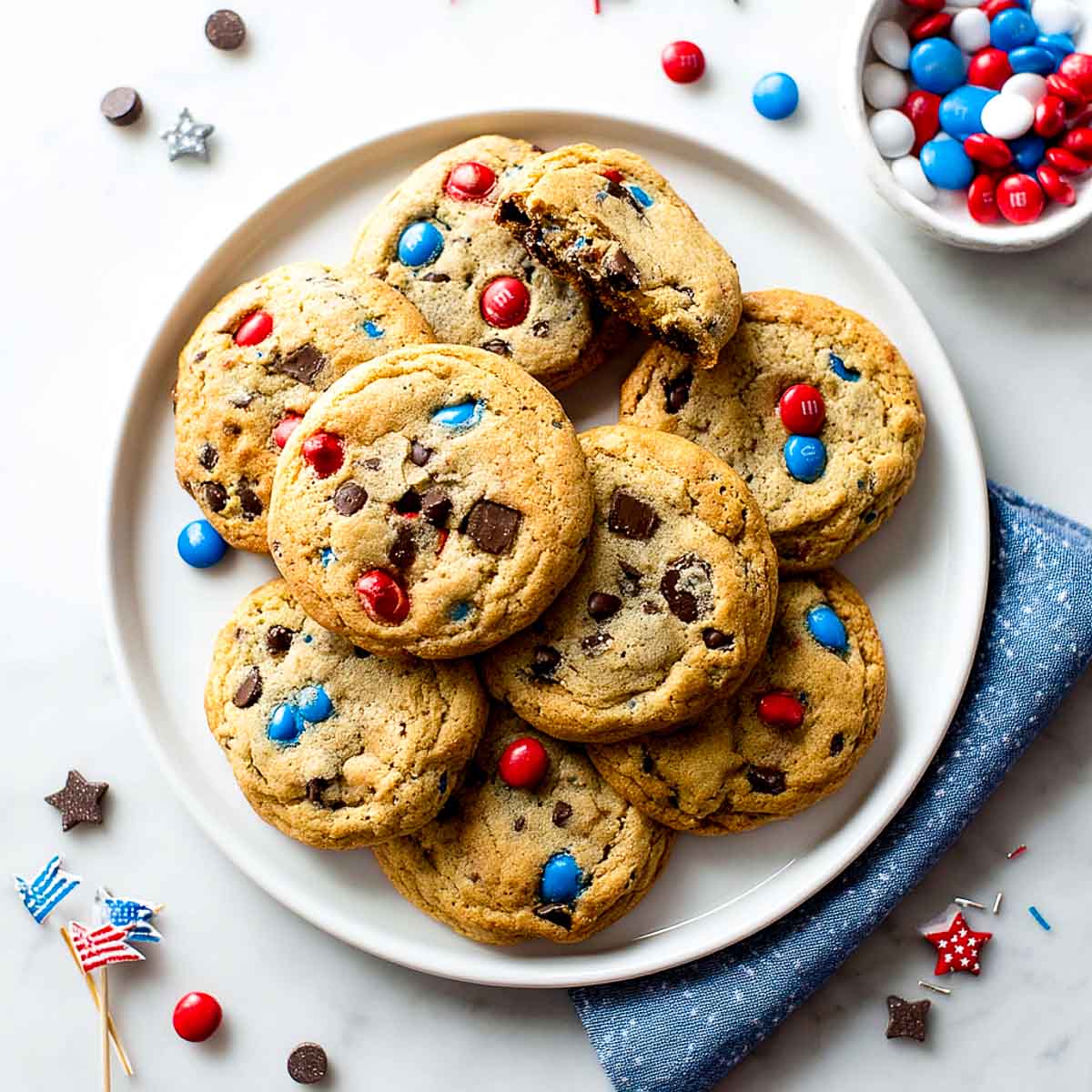 Top-down view of chocolate chip cookies with red, white, and blue candies.