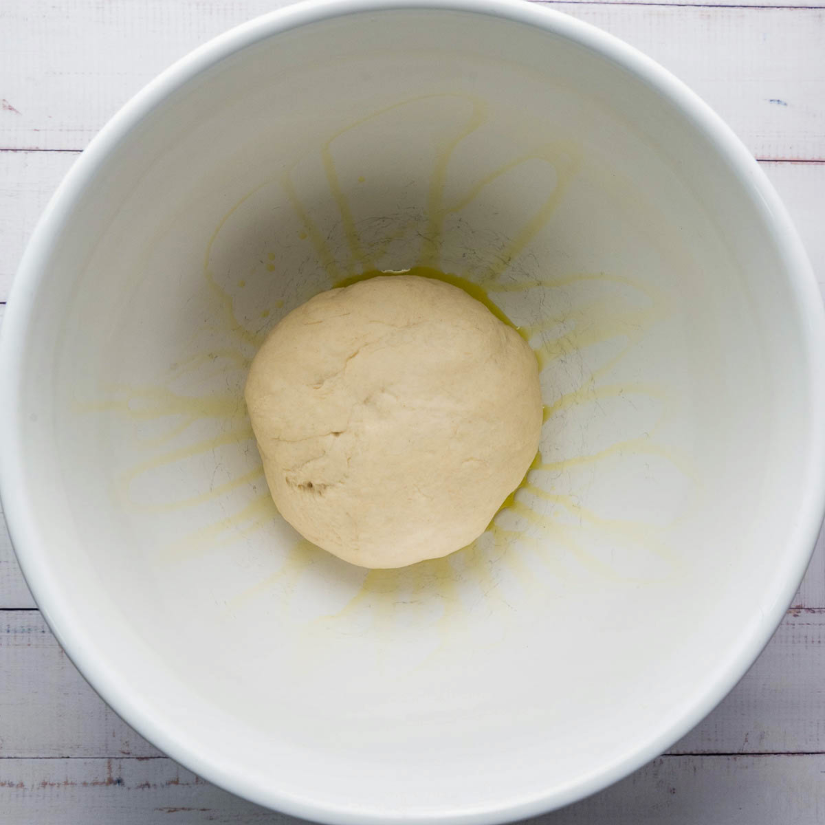 Smooth ball of dough in a lightly oiled bowl.