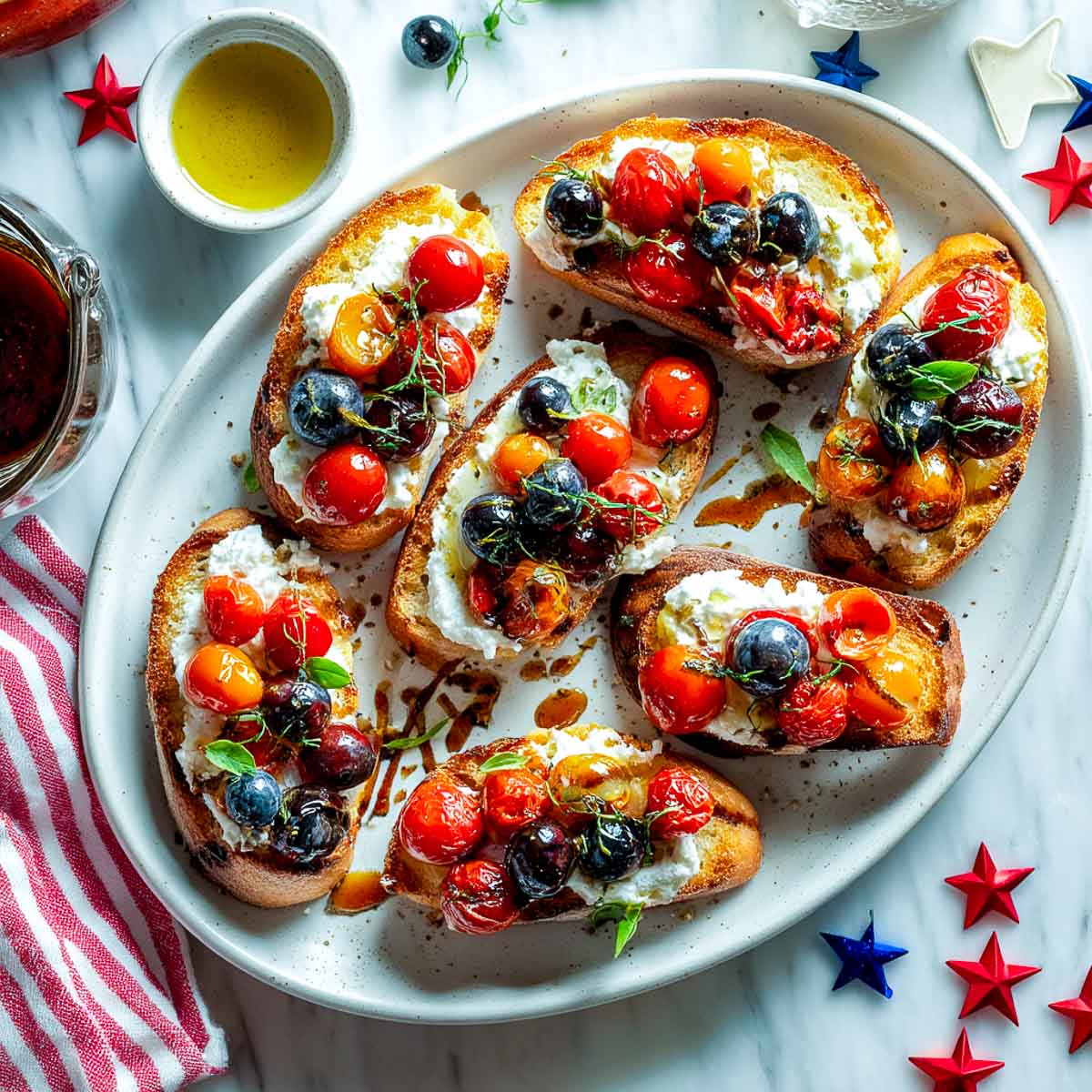 Toasted crostini with whipped feta, sautéed cherry tomatoes, blueberries, and balsamic drizzle.