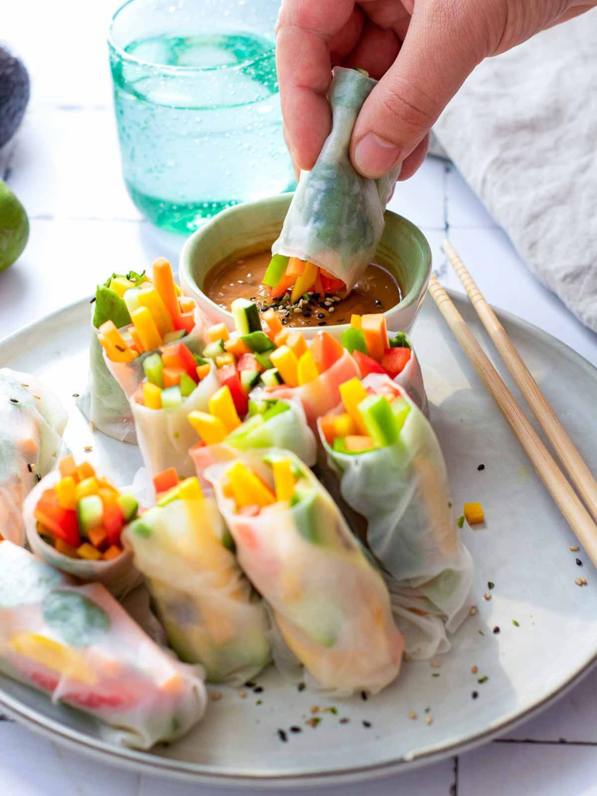 A rice paper roll dipped into hoisin sauce.