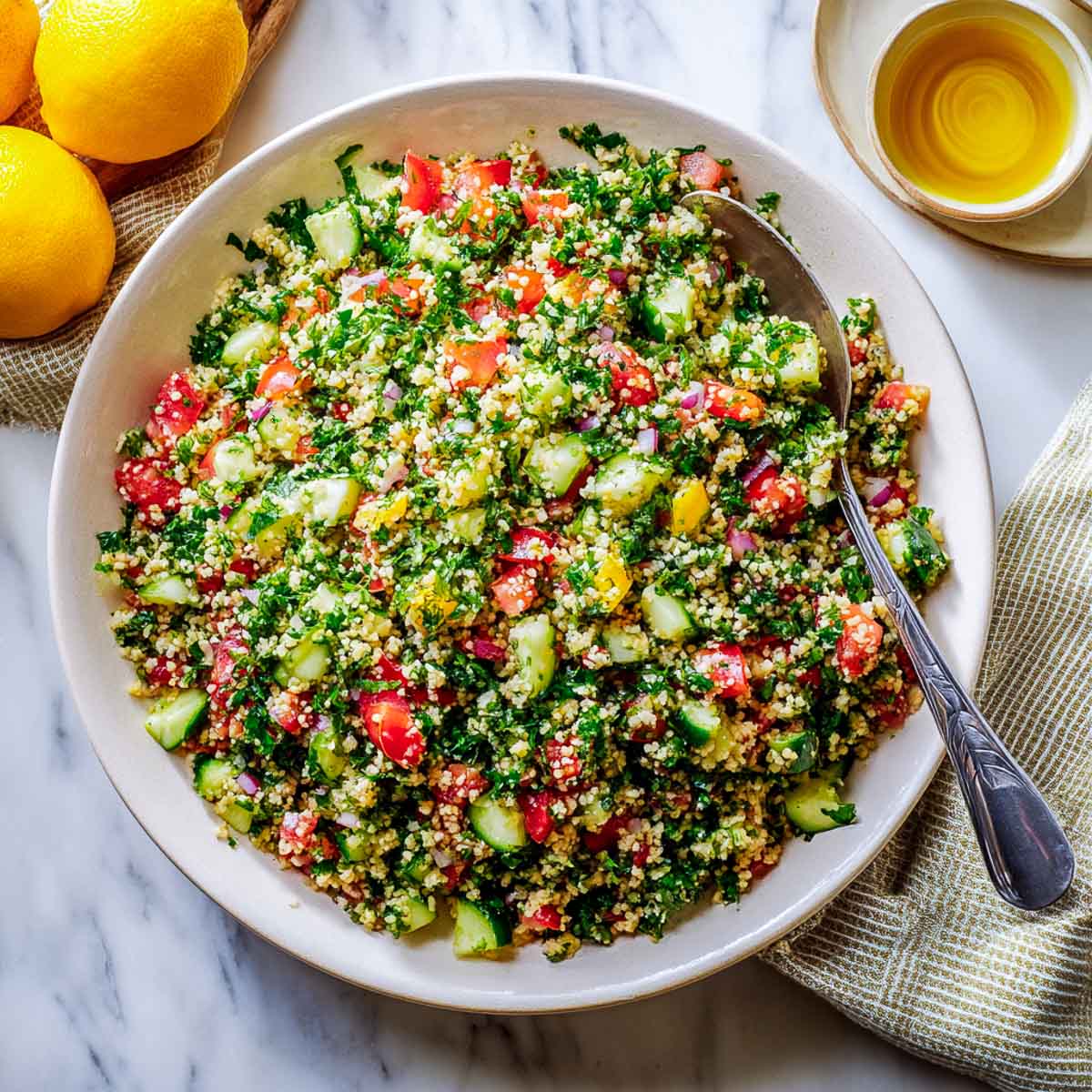 Tabbouleh salad with parsley, bulgur, tomato, and cucumber in white bowl.