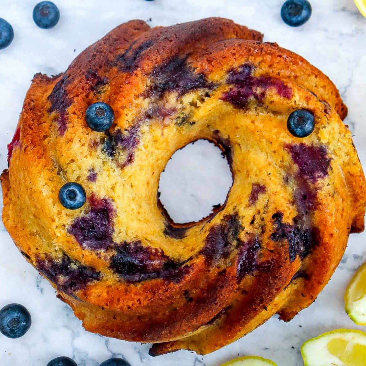 Baked lemon blueberry bundt cake fresh out of the oven with a golden crust and visible blueberry swirls.