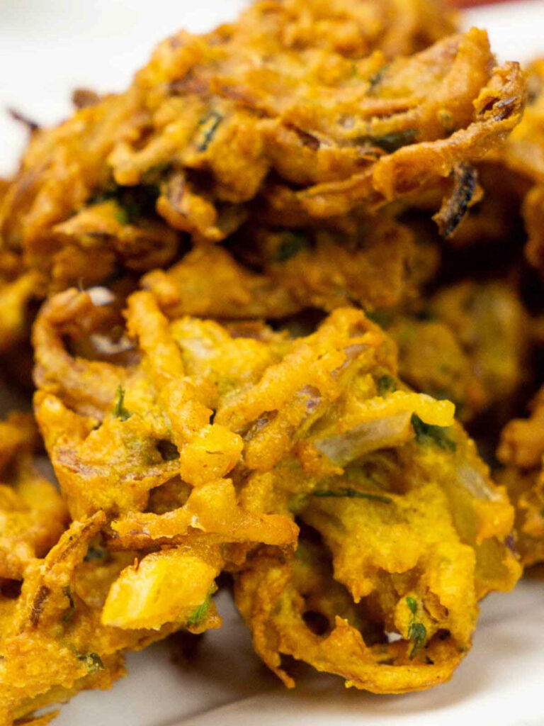 Zoomed-in view of crunchy onion pakoras showing fried texture and visible onion strands.