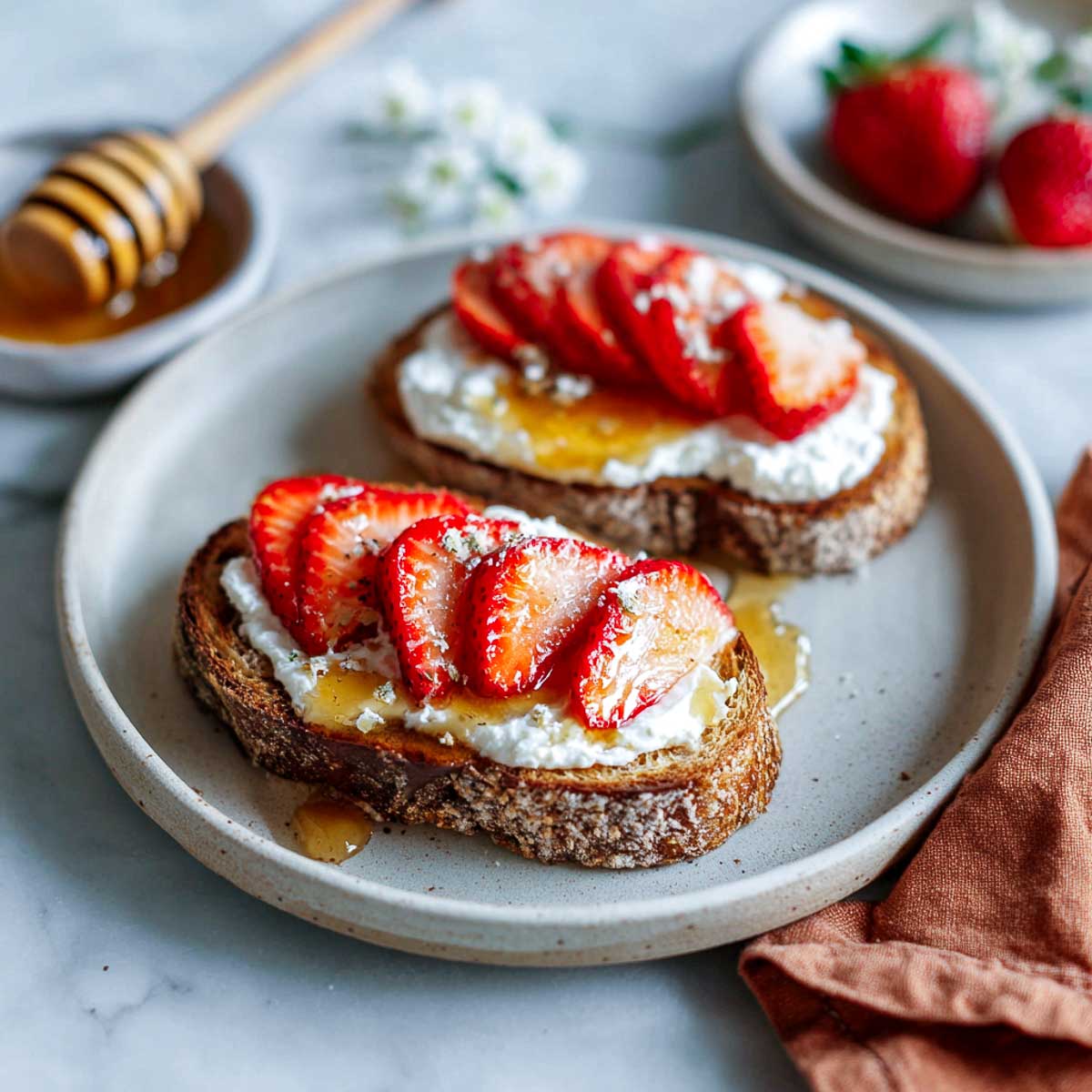 Toast with whipped ricotta, sliced strawberries, and honey drizzle.