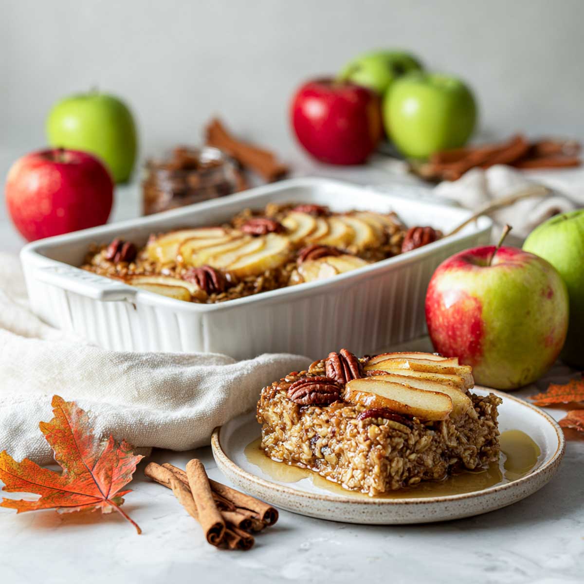 Side view of apple baked oatmeal topped with cinnamon and pecans.