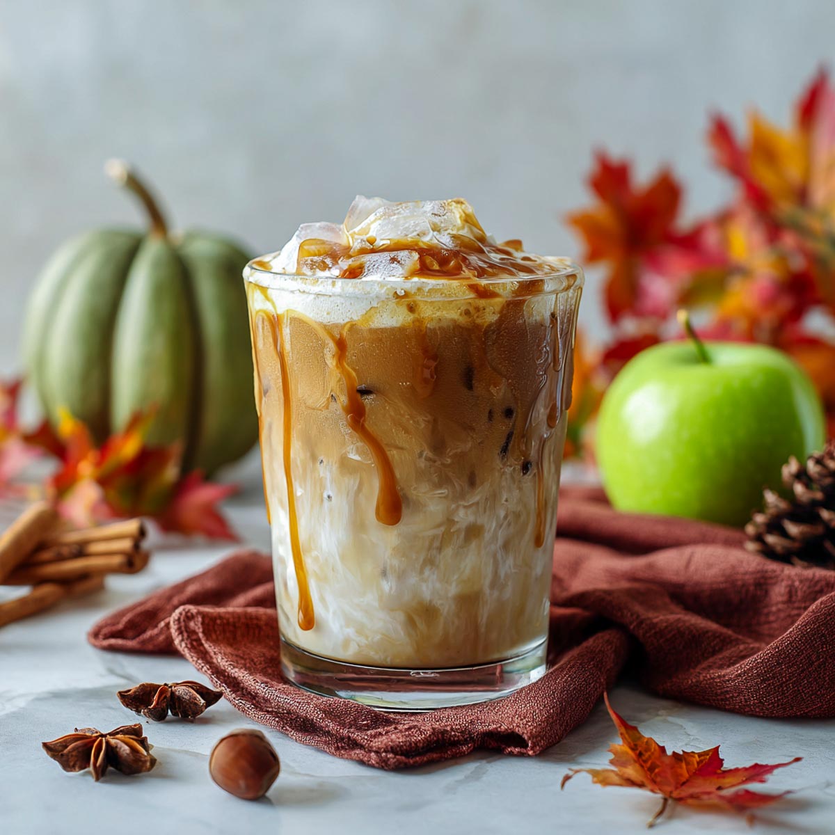 Iced white mocha in glass with caramel and pumpkin cold foam.