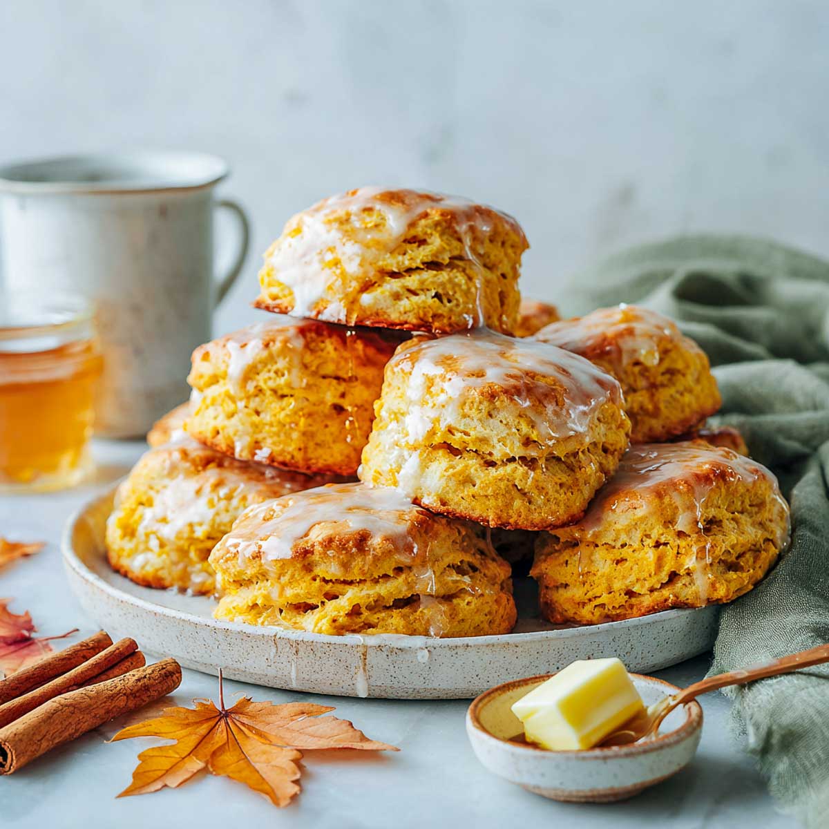 Maple glazed sweet potato biscuits stacked on a ceramic plate.