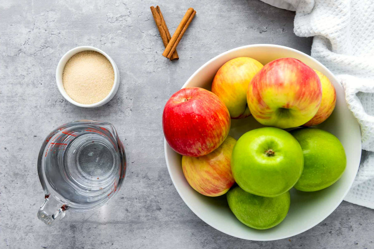 Fresh apples, sugar, cinnamon sticks, and water measured out for Instant Pot applesauce.
