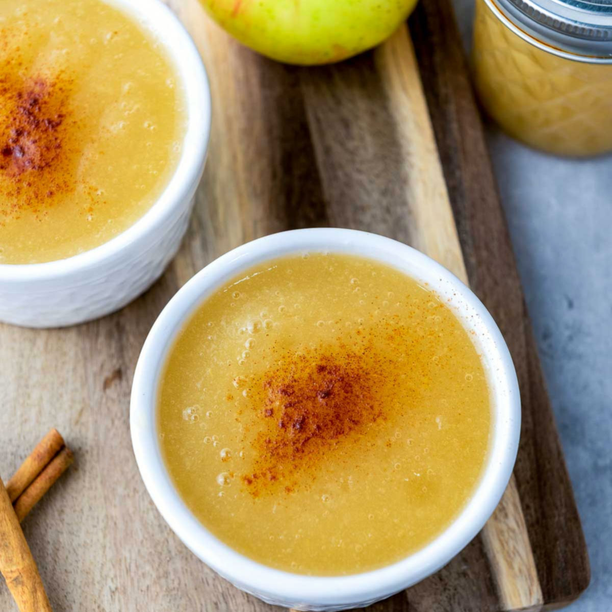 Close-up of smooth Instant Pot applesauce served in a white ramekin with cinnamon on top.