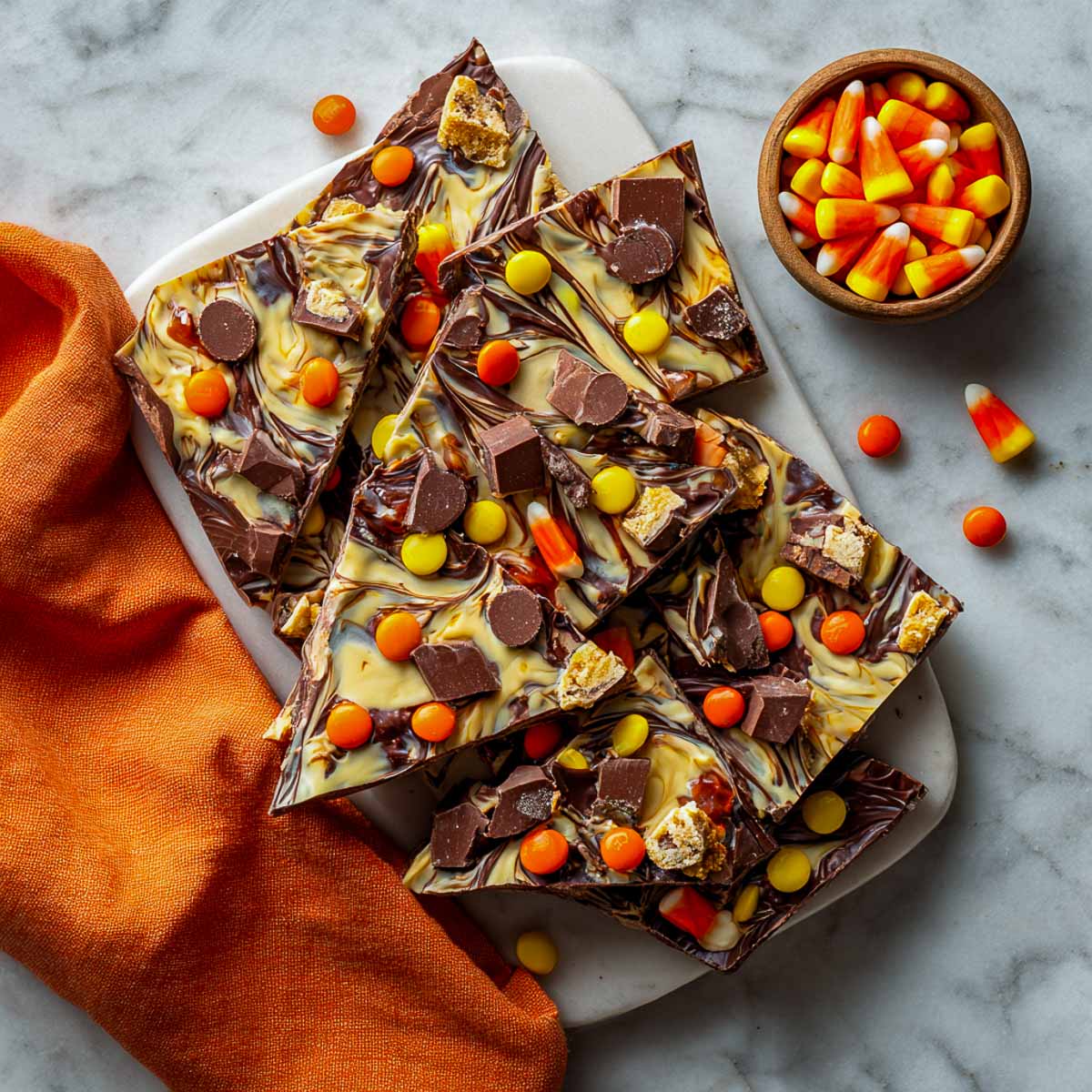 Colorful Halloween candy bark with swirled chocolate and candy toppings.