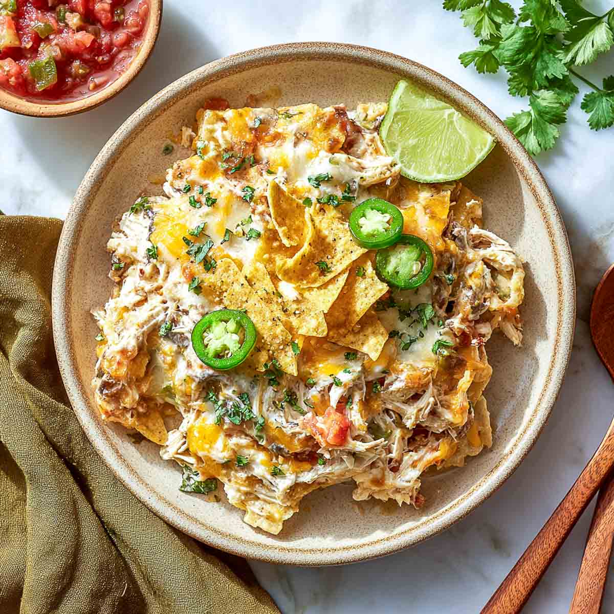 Top-down view of chicken taco casserole with chips, cheese, and cottage cheese.