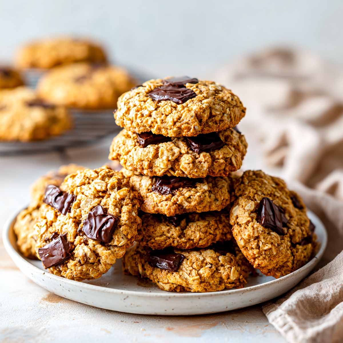 Pumpkin spice oatmeal cookies with dark chocolate chunks on a plate.