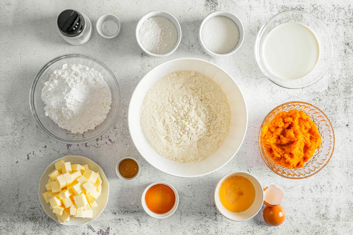 Overhead view of pumpkin scone ingredients including flour, butter, pumpkin, and spices.