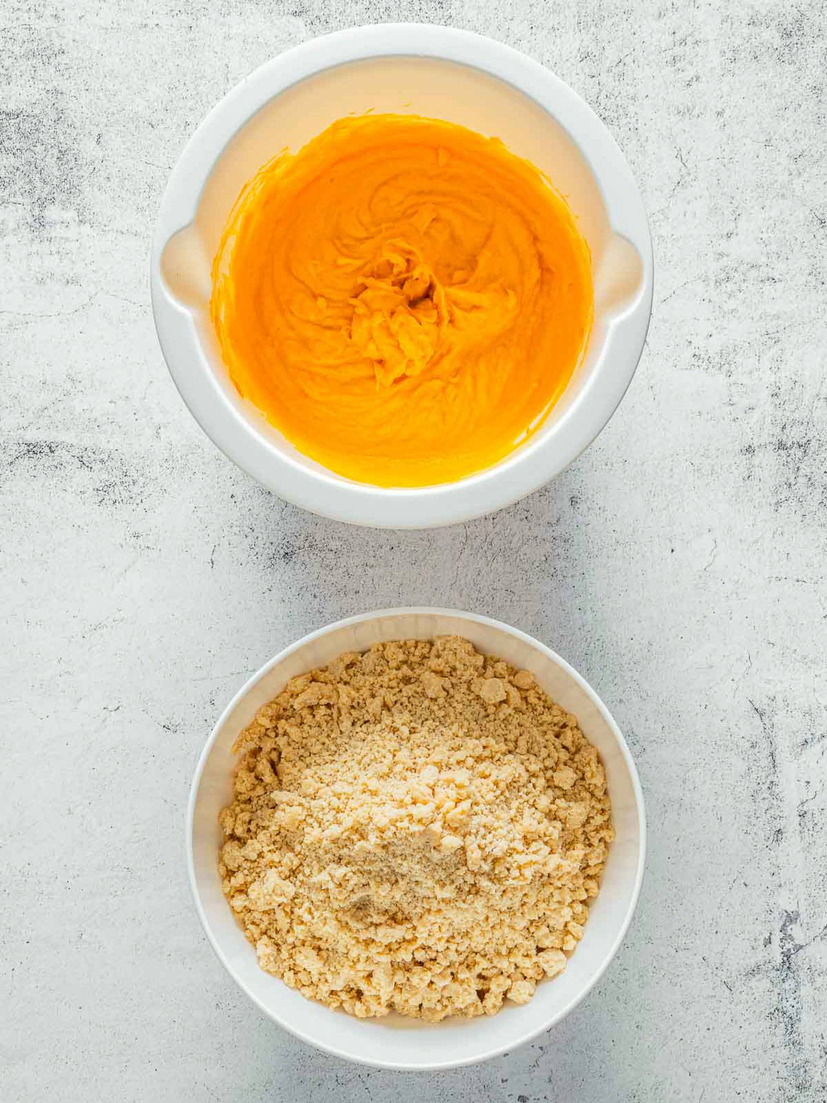 Pumpkin puree mixture and flour butter mixture in two white mixing bowls.