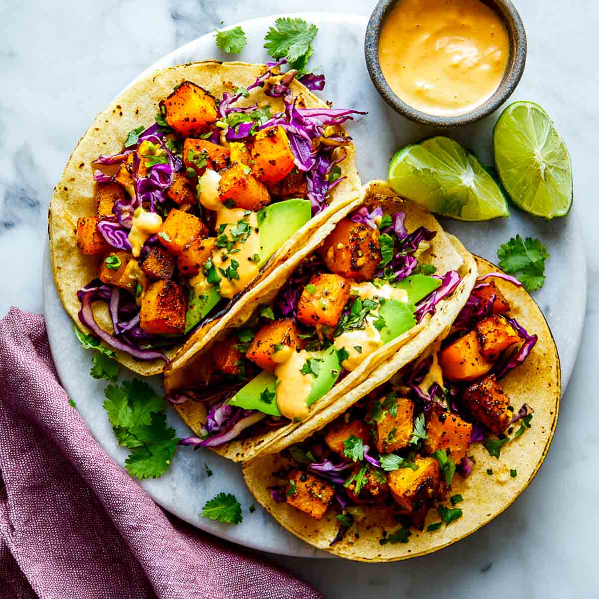 Soft corn tortillas filled with roasted butternut squash, cabbage, avocado, and chipotle aioli.