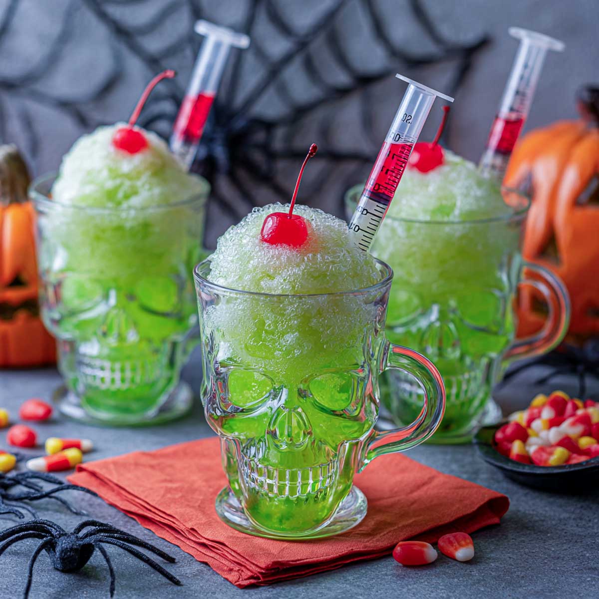 Green slush Halloween skull potion with red poison syringe and cherry.