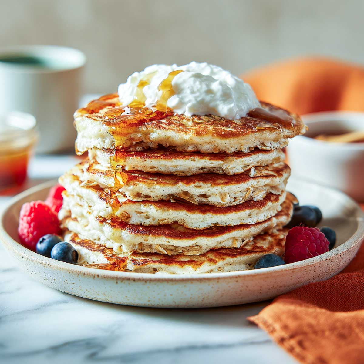 Angled side view of vegan protein pancakes topped with cottage cheese and syrup.