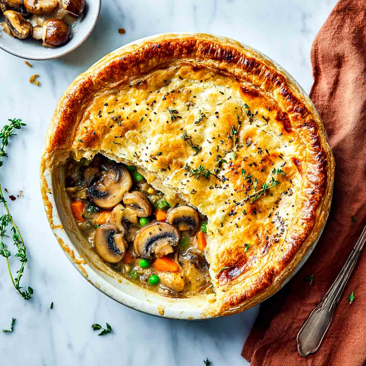 Golden vegan mushroom pot pie with flaky crust and vegetable filling.