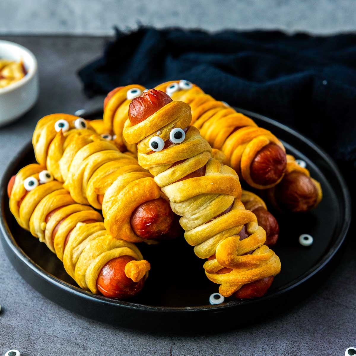 Wrapped hot dogs placed in air fryer basket before cooking.